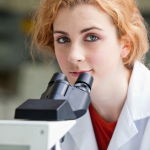 Close up of a young student posing with a microscope