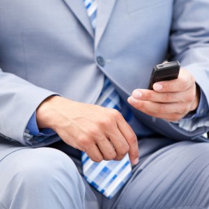 Close-up of a businessman sitting on a wheelchair sending a text