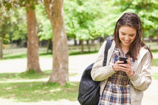 Young student using a smartphone in a park