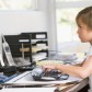 Young boy in home office with computer typing