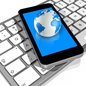 world globe on a mobile phone on a computer keyboard