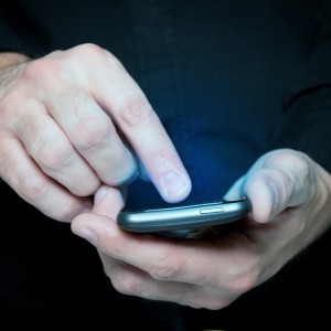 Man typing a text message on a smartphone