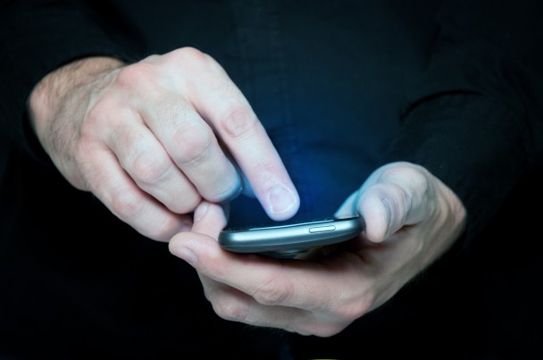 Man typing a text message on a smartphone
