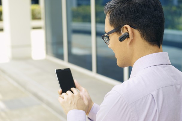 Businessman Calling On Mobile Phone With Bluetooth Handsfree